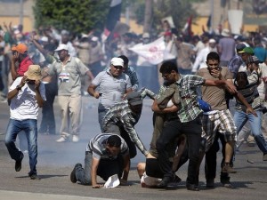 Supporters of ousted Egyptian president Mohammed Morsi rush to help a wounded man after a gunbattle erupted outside the Cairo headquarters of the Republican Guard on Friday. (Photo: Mahmud Hamsud, AFP/Getty Images) 