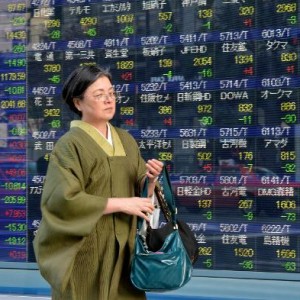 A woman walks past an electronic share prices board in Tokyo on March 3, 2014  (AFP, Yoshikazu Tsuno) 