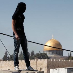 A Palestinian stone thrower watches the situation during clashes in the East Jerusalem neighborhoodof Ras al-Amud, on February 28, 2014  (AFP/File, Ahmad Gharabli) 