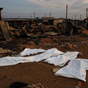 Dead bodies covered in plastic lie in front of a burnt out marketplace in Bor on February 1, 2014  (AFP, Carl De Souza)