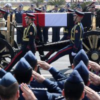 Officers salute as the horse-drawn carriage transporting the flag-draped coffin former Egyptian President Hosni Mubarak passes by during the funeral at Mosheer Tantawy mosque